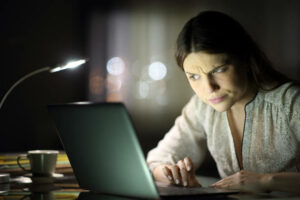 An image of a Suspicious woman checking laptop content in the night